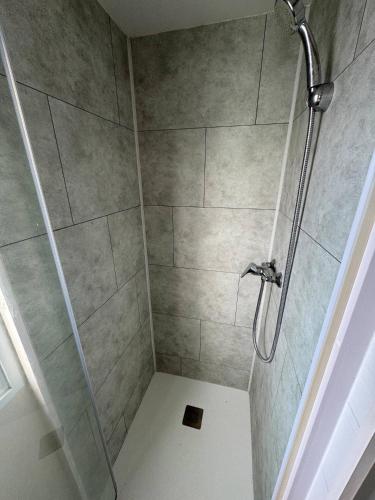 une douche avec une porte vitrée dans une salle de bain dans l'établissement Bungalow Balnéo Jacuzzi Sauna, à Erquy