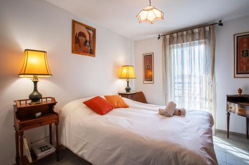 une chambre avec un lit avec deux lampes et une fenêtre dans l'établissement Jardin Wilson AP4455 by RIVIERA HOLIDAY HOMES, à Nice