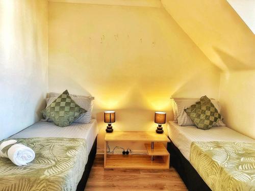 two twin beds in a room with two lamps at Modern 3 Bed House In Essex By DLuxoria Short Lets & Serviced Accommodation With Pet Friendly, Free WiFi & Free Parking in Basildon