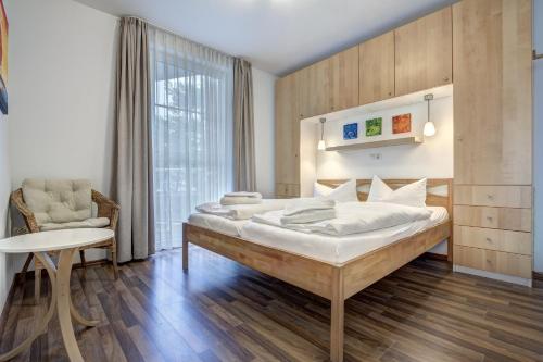 Ostseeresidenz Gorki- Park - 09 mit Wellness und Schwimmbad في بانسين: غرفة نوم بها سرير كبير وكرسي