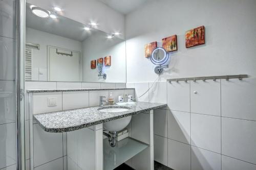 Ostseeresidenz Gorki- Park - 09 mit Wellness und Schwimmbad في بانسين: حمام أبيض مع حوض ومرآة