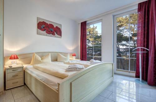 a bedroom with a large bed and a large window at Ostseeresidenz Gorki- Park - 11 mit Wellness und Schwimmbad in Bansin