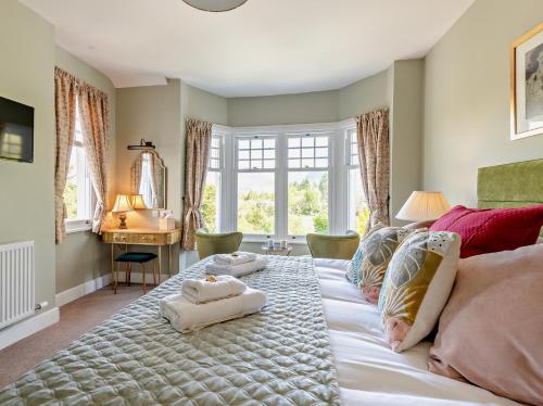 Bassenthwaite Lake4 Bed in Bassenthwaite 91210的卧室里有一张大床，床上铺着毛巾。