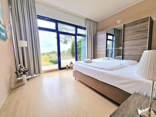 a bedroom with a large bed and a large window at Bella Vita in Trassenheide
