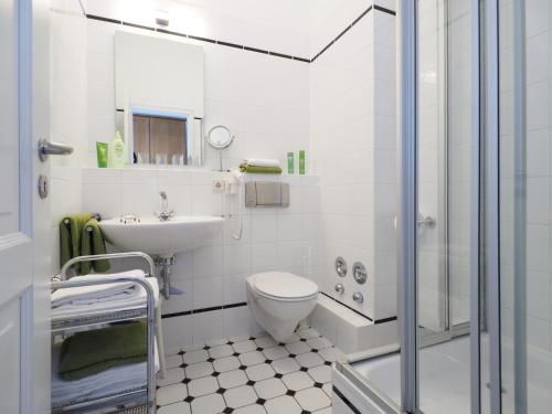 a white bathroom with a toilet and a sink at Villa Bismarckshöhe Wohnung Gertrud in Ahlbeck