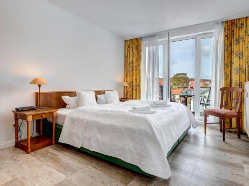 a bedroom with a large bed and a large window at Seehof Wohnung 1.33 in Bansin