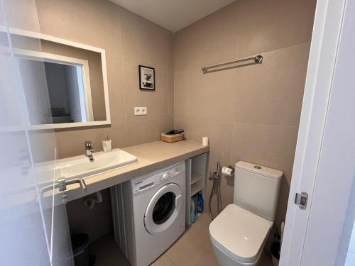 a bathroom with a washing machine and a sink at Villa Majunaxa in Corralejo