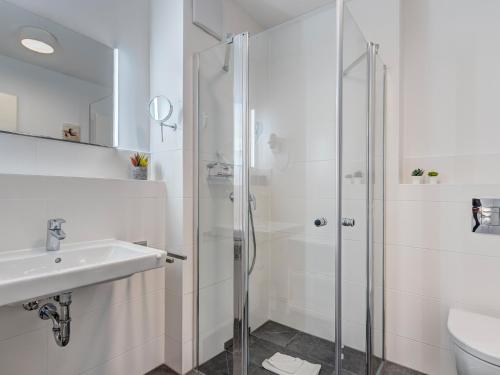 a white bathroom with a shower and a sink at Bernsteinquartier BQ 9c Ostseenest in Kolpinsee