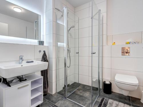 een badkamer met een wastafel en een douche bij Bernsteinquartier BQ6b - Haus Lachmöwe in Kolpinsee