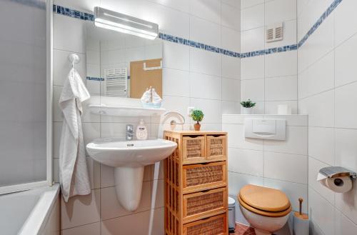 une salle de bain avec un lavabo, des toilettes et une baignoire dans l'établissement Haus Berlin Loddiner Höft, à Loddin