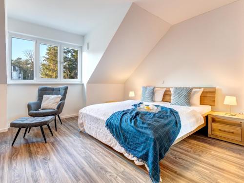 een slaapkamer met een bed en een stoel bij Bersteinquartier BQ 10c in Kolpinsee