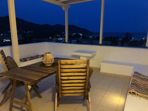 a wooden table and chair on a balcony at night at Mylopota Studio I in Mylopotas