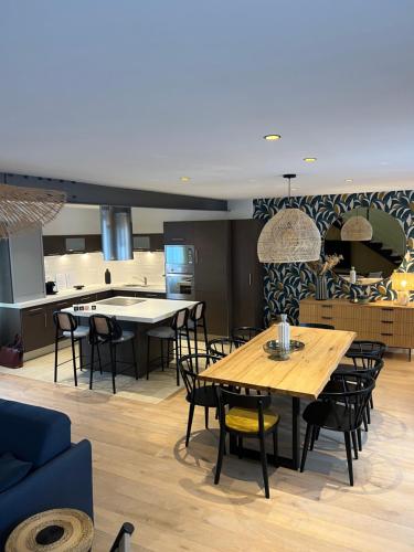 Il comprend un salon avec des tables et des chaises ainsi qu'une cuisine. dans l'établissement Jerzual-Grand Duplex Dinan centre-ville, à Dinan