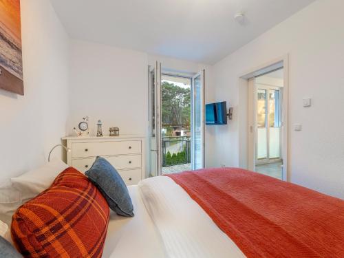 a bedroom with a bed and a dresser and a window at Ferienwohnung Eichhorst in Trassenheide