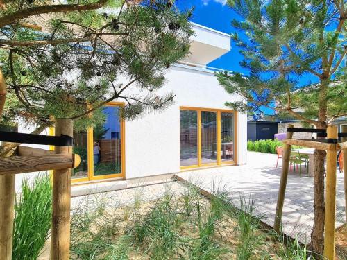 a house with yellow windows and a patio at Ferienhaus Inselliebe mit Sauna in Zempin