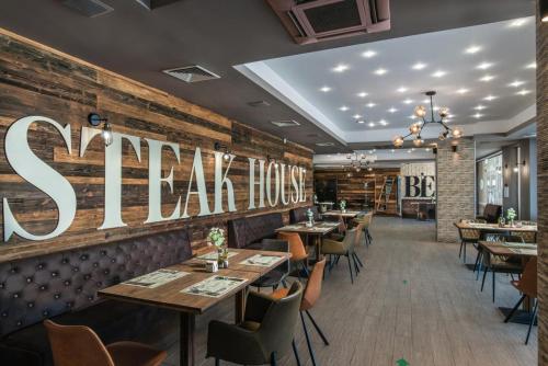 a restaurant with tables and chairs and a sign on the wall at Aparthotel - Apartment with a large terrace and direct access to the sea in Obzor