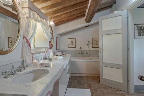 a bathroom with a sink and a tub and a mirror at Luxury Pool Villa Oliveto 12 - Belcantovillas in Marlia