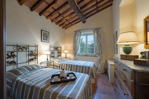 a bedroom with two beds with a tray on it at Luxury Pool Villa Oliveto 12 - Belcantovillas in Marlia