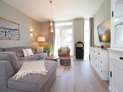 a living room with a couch and a table at Fischerhus Loddin mit Sauna und Kamin in Loddin