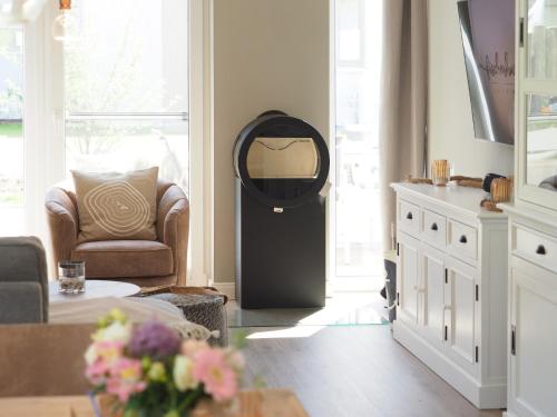 a living room with a black door and a chair at Fischerhus Loddin mit Sauna und Kamin in Loddin