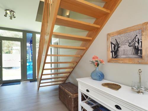 a staircase in a living room with a vase of flowers at Fischerhus Loddin mit Sauna und Kamin in Loddin