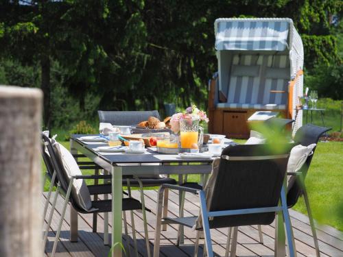 a table with food on it with chairs and a grill at Fischerhus Loddin mit Sauna und Kamin in Loddin