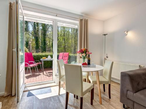ein Wohnzimmer mit einem Tisch und Stühlen sowie eine Terrasse in der Unterkunft Hansehus Ferienwohnung Nr 3 in Zinnowitz