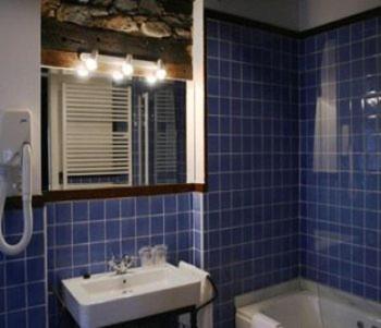 a blue tiled bathroom with a sink and a tub at Hotel Rural Casa Xusto in La Caridad