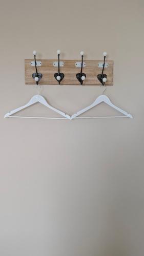 un portemanteau en bois avec quatre cintres dans l'établissement Chambre Rose Blanche, au Lude