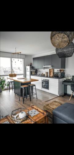 un salon avec une table et une cuisine dans l'établissement APP 25 Appartement contemporain lumineux avec terrasse, à Vitré