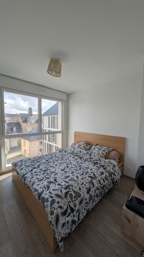 una camera da letto con un letto e una grande finestra di Appartement contemporain lumineux avec terrasse a Vitré