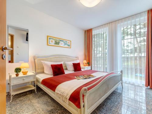 a bedroom with a large bed with red pillows at Ostseeresidenz Gorki- Park - 03 mit Wellness und Schwimmbad in Bansin