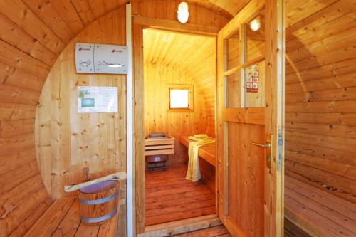 een houten kamer met een deur in een hut bij Ferienhaus am Eikboom - DHH2 mit Fasssauna in Ostseebad Karlshagen