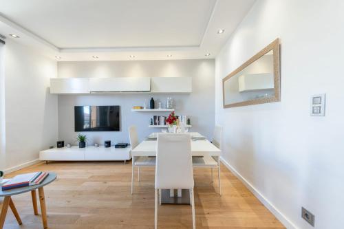 une salle à manger blanche avec une table et des chaises blanches dans l'établissement Air-Conditioned 2-Br Apartment with Garage Near the Beach, à Cannes