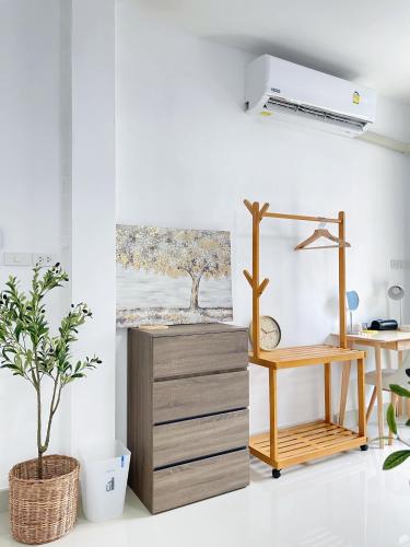 an office with a desk and a table with a plant at The Cozy Lazy Home Hatyai in Hat Yai