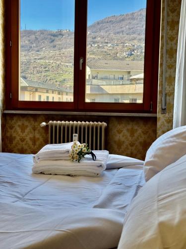 a bed with a bouquet of flowers on top of it at Nido tra monti in Sondrio