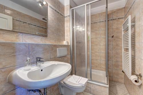 a bathroom with a sink and a shower and a toilet at Ferienzimmer Küstensonne in Zinnowitz