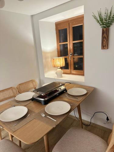a wooden table with plates on it in a room at La Maison de Victoire et Alix in Pontrieux