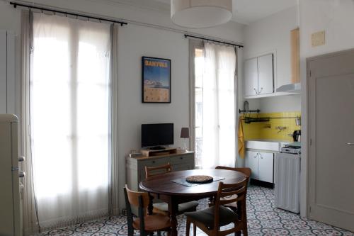 une cuisine avec une table et des chaises dans une pièce dans l'établissement Tranquillité à 2 pas de la plage, à Banyuls-sur-Mer