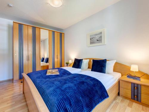 une chambre avec un grand lit avec une couverture bleue dans l'établissement Ostseepark Waterfront Karavelle Wohnung 3.5, à Bansin