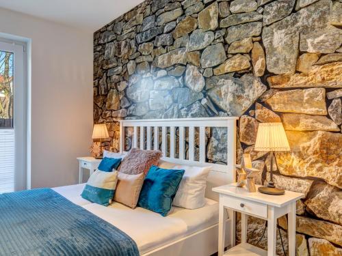 a bedroom with a stone wall at Villa Maarten mit Sauna in Zempin