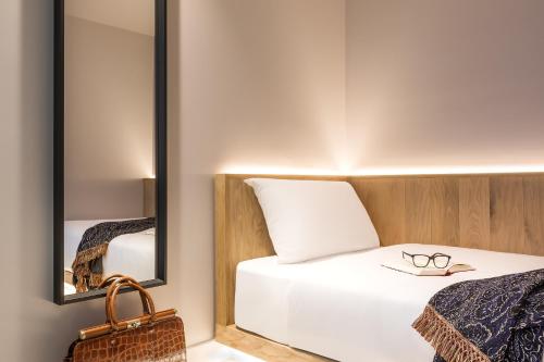 a bedroom with a bed and a mirror at Zedwell Underground Hotel Tottenham Court Rd in London