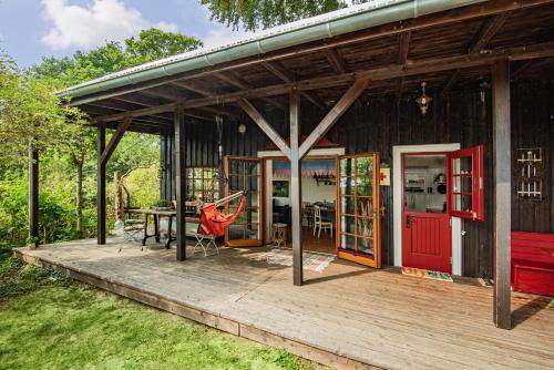 a house with a red door and a wooden deck at Kleiner Wagen - Stubbenfelde in Stubbenfelde