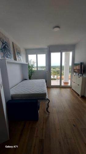 a bedroom with a bed in the middle of a room at Apartamento con piscina in Matalascañas