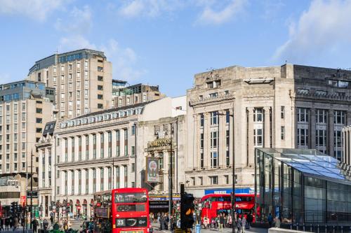 a busy city street with red double decker buses at Zedwell Underground Hotel Tottenham Court Rd in London
