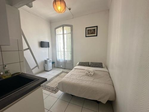 une chambre avec un lit avec un animal en peluche dessus dans l'établissement Les Balconnets Studios Nice centre ville, à Nice