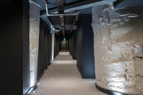 a hallway in a building with columns and lights at Zedwell Underground Hotel Tottenham Court Rd in London