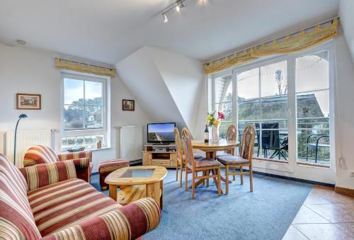 a living room with a table and chairs and a tv at Haus Ostseeglück - Ferienwohnung Morgensonne mit Gemeinschaftssauna in Loddin