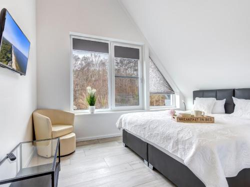 a white bedroom with a bed and a window at Ferienhaus Rosa in Ostseebad Karlshagen