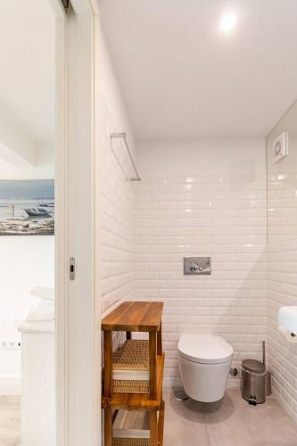 a white bathroom with a toilet and a table at Villa Margaritta in Sintra
